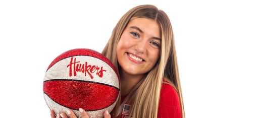 Logan Nissley holding a Huskers branded basketball